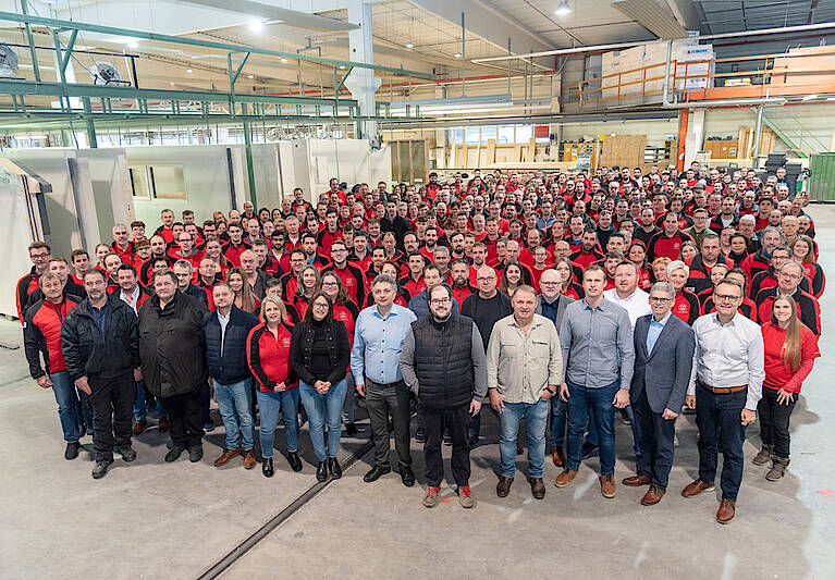 Bild des gesamten Hartl Haus Teams. Über 100 Personen in einer Halle stehend