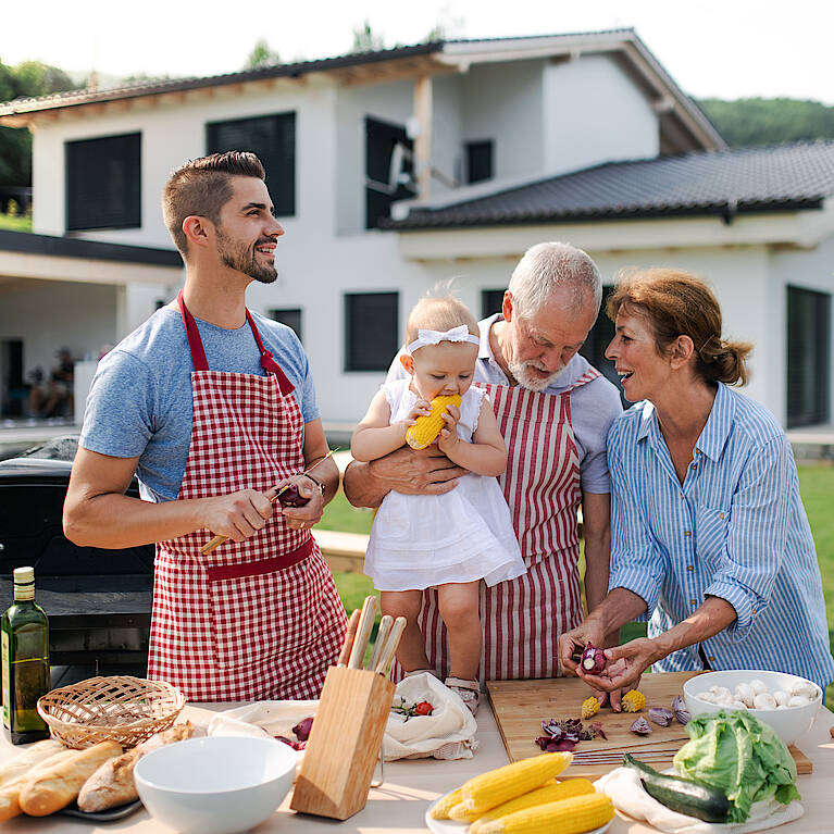 Glückliche Familie beim Kochen im Garten