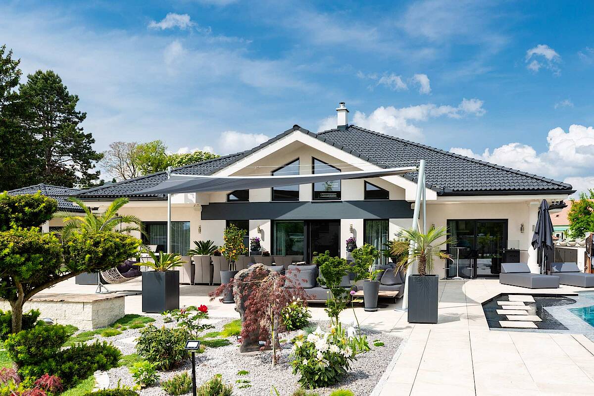 Haus mit großer Terrasse und Pool rechts im Bild