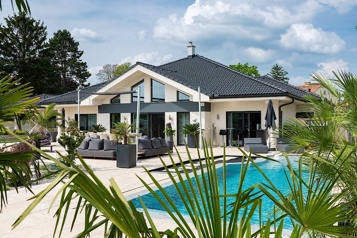 Große Terrasse mit Pool, Palmblätter im Vordergrund