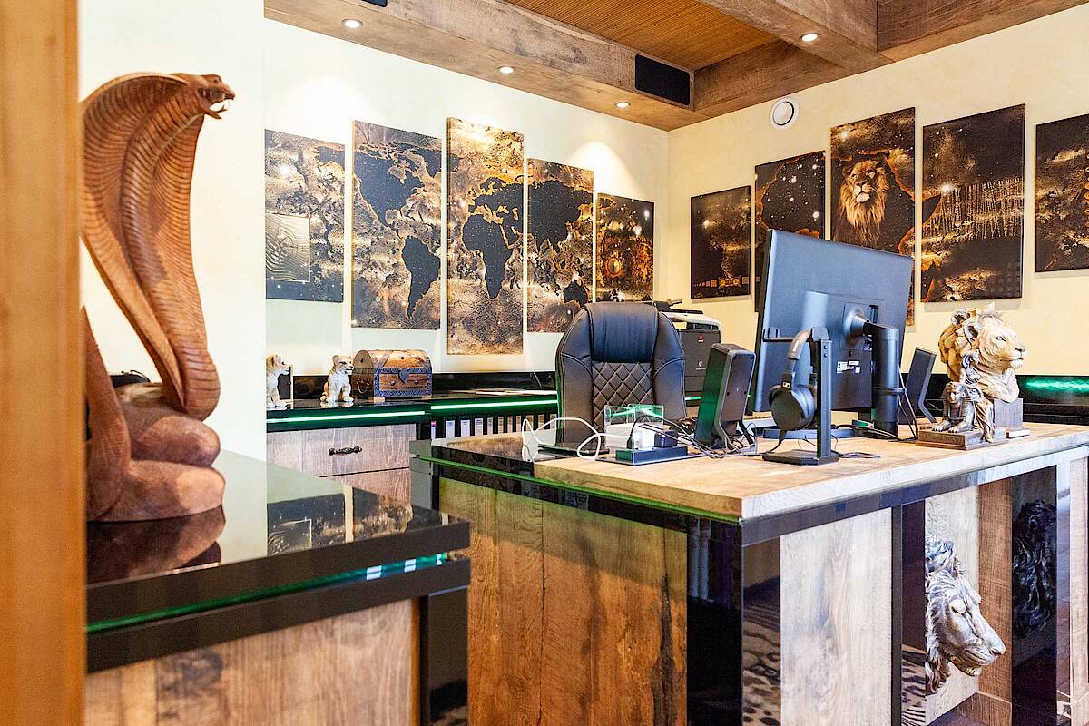 Arbeitszimmer mit Schreibtisch. Dekoration mit Löwenstatuen und Cobra-Statue aus Holz