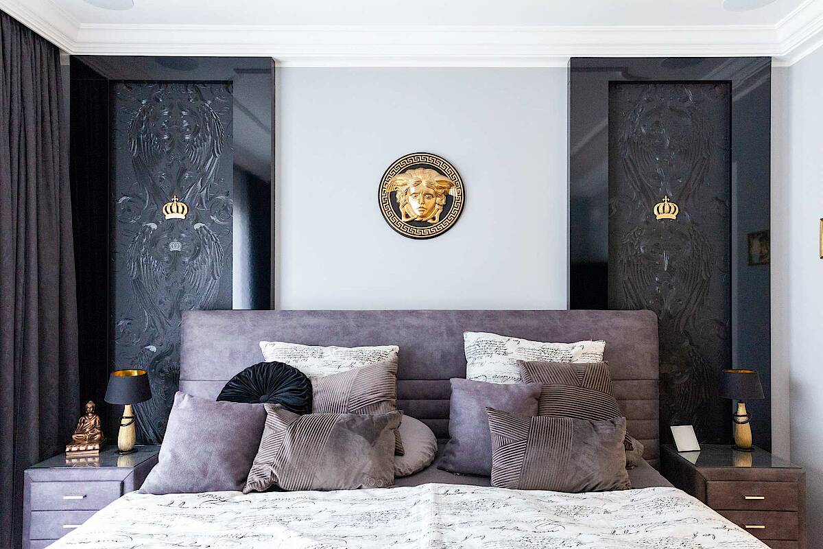 Blick auf das Bett, schwarz-weiße Rückwand mit Goldakzenten