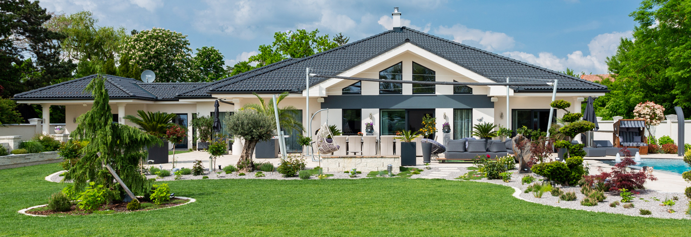 Großer Garten mit Terrasse und Haus im Hintergrund