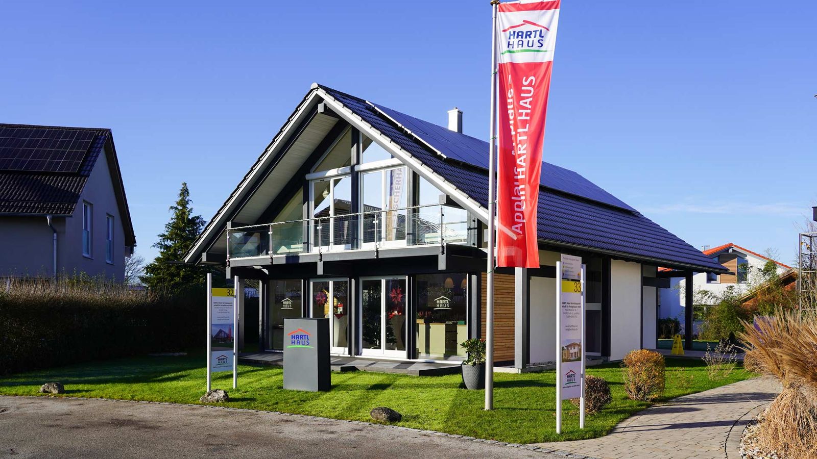 Musterhaus im HARTL HAUS Bauerlebniszentrum München mit Fahne am Eingang