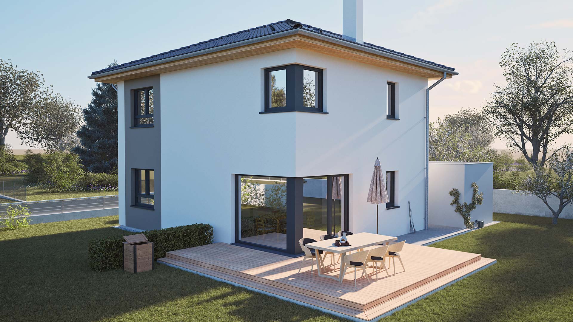Moderne Rückansicht eines Hartl Haus Fertighauses mit Terrasse und Esstisch im Garten.