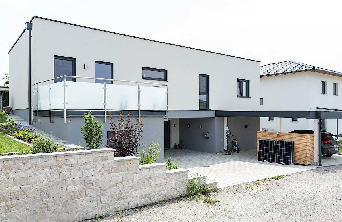 Vorderseite des Hauses mit Carport und Balkon, überdachter Eingangsbereich in der Mitte