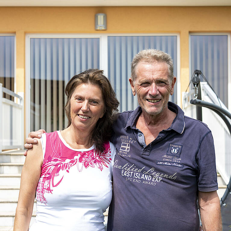 Portrait der beiden Hausbesitzer, Mann legt Arm um die Schulter der Frau