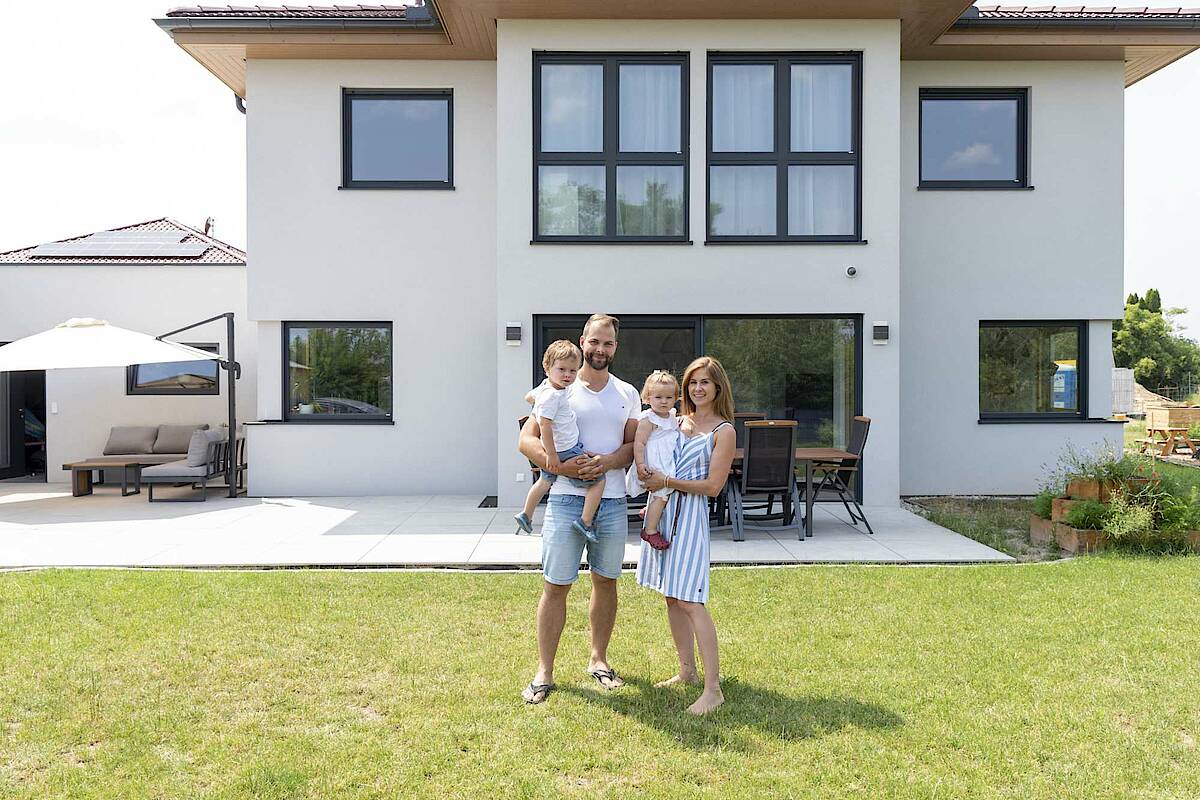 Familie mit zwei Kindern vor ihrem Hartl Haus im Garten