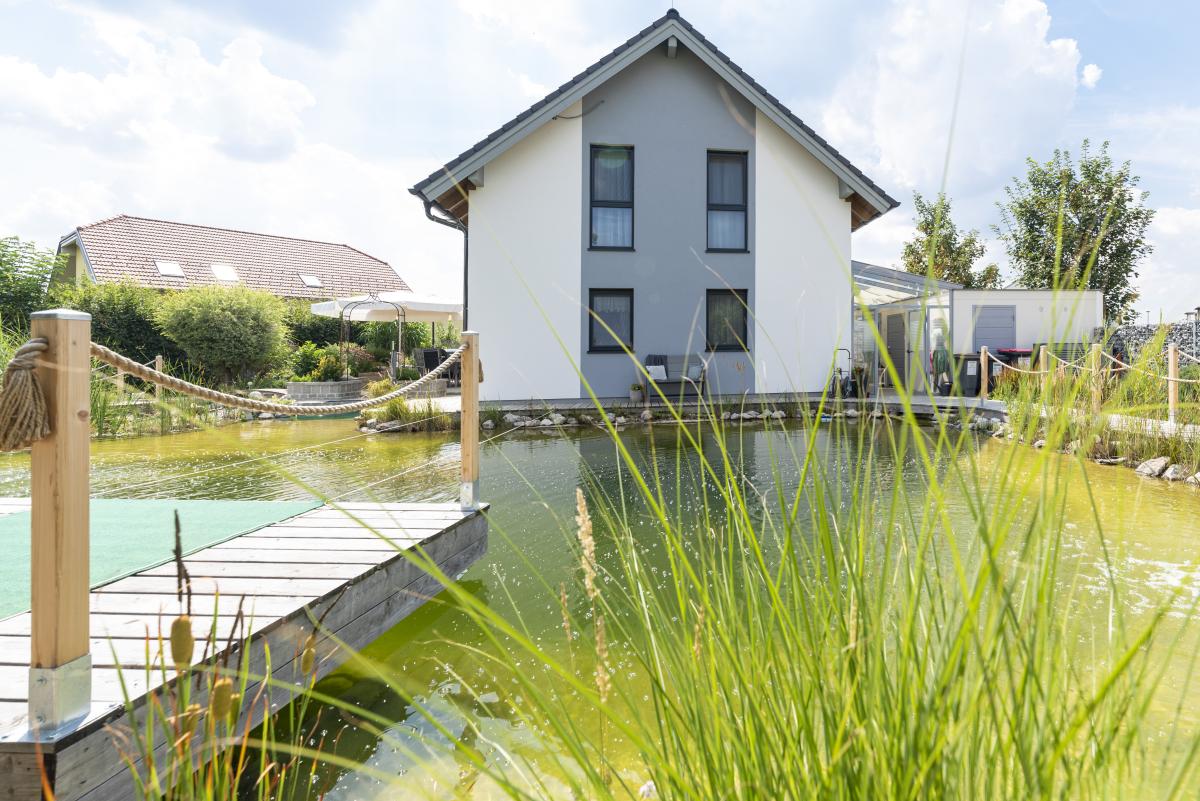 Einfamilienhaus mit großem Teich mit Steg im Garten