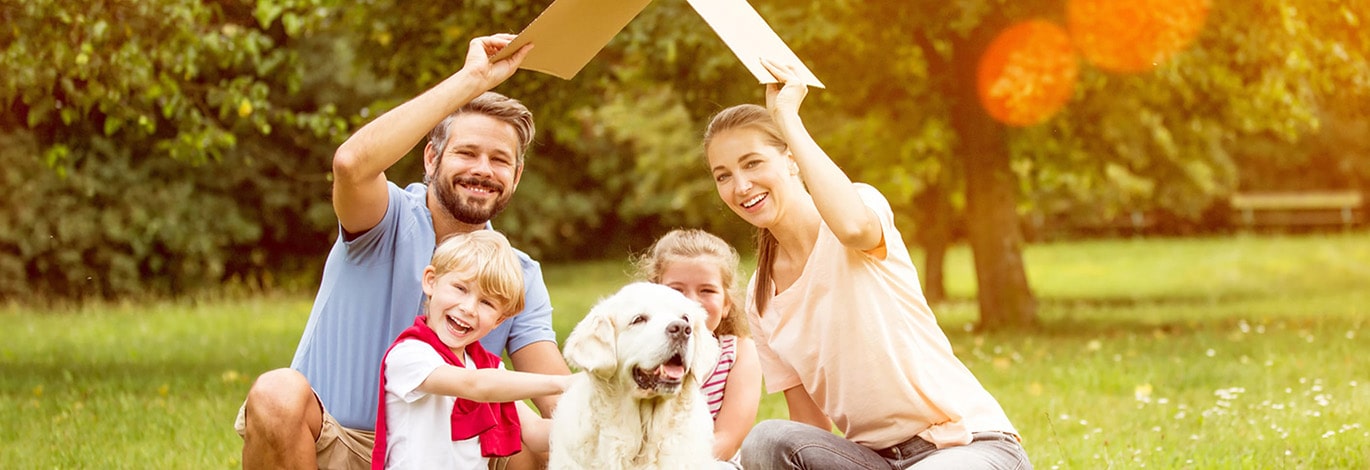 Familien mit zwei Kindern und Hund im Garten