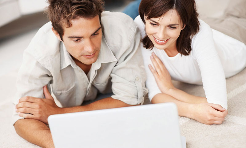 Mann und Frau schauen neugierig auf Laptop